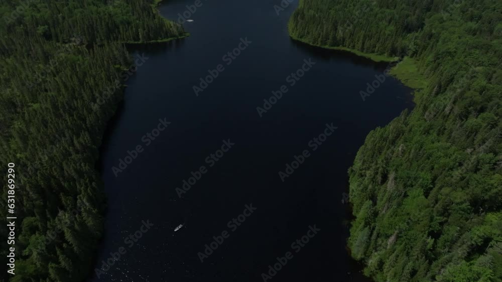Aerial of a calm lake surrounded by dense calm forest during the early morning Aerial of a calm lake surrounded by dense calm forest during the early morning