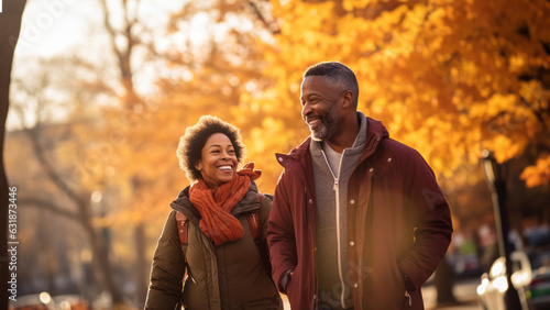 Middle age black couple smiling and walking in the fall