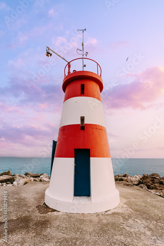 White red lighthouse on the shore in Sesimbra, Portugal.