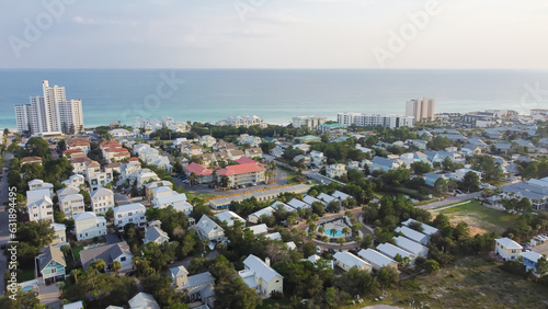 White three-story vacations homes, condo buildings surrounding by lush green trees in beach neighborhood along county road 30A, Gulf shoreline and Emerald Coast Santa Rosa, Florida, USA photo