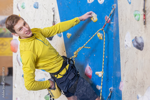 Young climber climbing indoor wall, sport concept