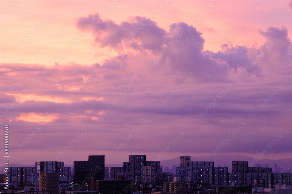 都市の夜明け。暑い雲で覆われた東の空が明るくなりドラマチックな一日が始まる予感。兵庫県神戸市で撮影。