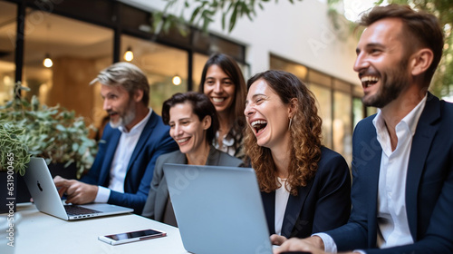 Cheerful Business Colleagues Watching a Presentation on a Laptop