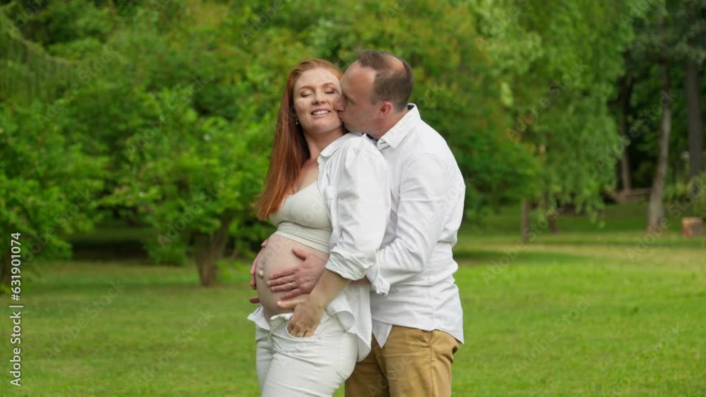 Family day. Man hugging and touching woman belly outdoors. Pregnant couple outdoors. Happy parenthood concept. Pregnant belly. Love. 4K, UHD Family day. Man hugging and touching woman belly outdoors. Pregnant couple outdoors. Happy parenthood concept. Pregnant belly. Love. 4K, UHD