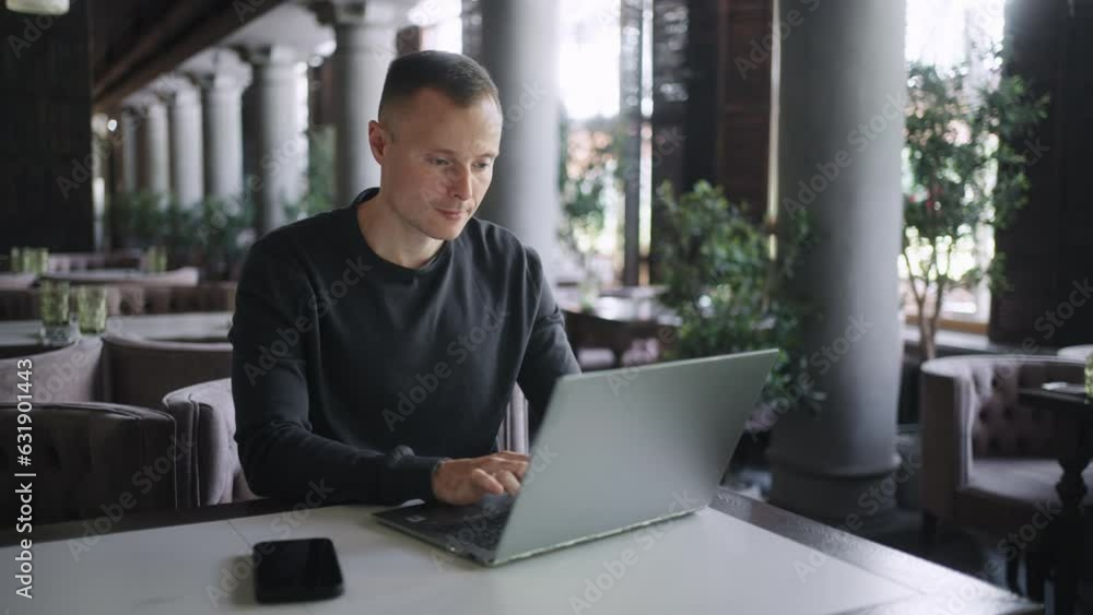 IT Professional Freelancer Man Working Remotely, Sitting In Cafe And Typing On Laptop Keyboard IT Professional Freelancer Man Working Remotely, Sitting In Cafe And Typing On Laptop Keyboard