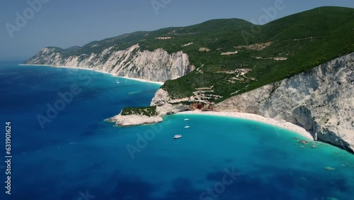 Aerial drone footage with panning motion of  Porto Katsiki in Lefkada, Greece. Sailing boats anchored in shallow turquoise sea waters near the Porto Katsiki beach  photo