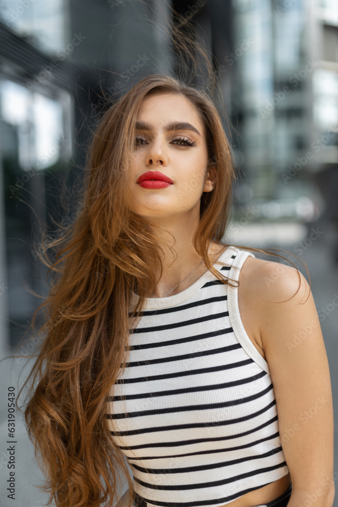 Fresh beautiful fashionable young woman with a cute face with red lips in trendy fashion summer clothes is walking in the city Fresh beautiful fashionable young woman with a cute face with red lips in trendy fashion summer clothes is walking in the city