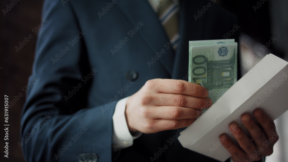 Man putting bribe envelope in office close up. Hands placing euro for corruption Man putting bribe envelope in office close up. Hands placing euro for corruption