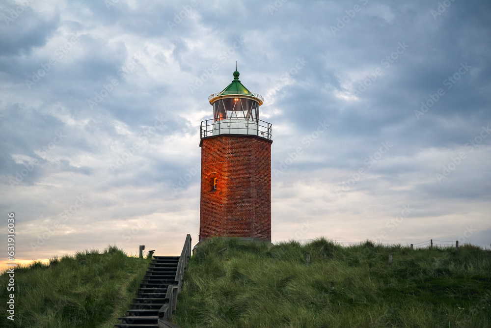 Redbricks lighthouse on the hilltop under a cloudy sky on Sylt Island, Germany