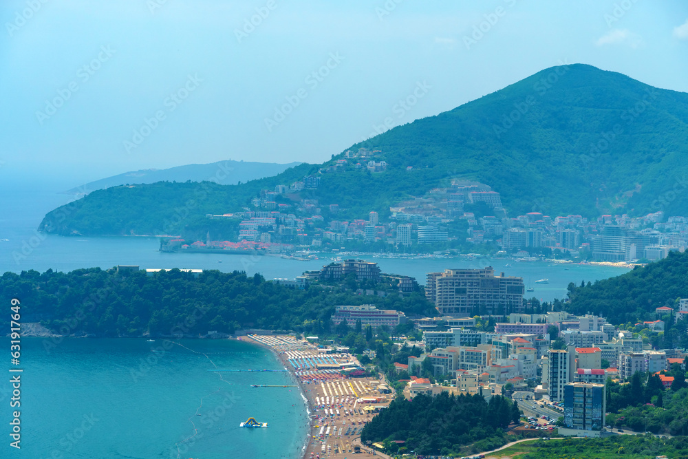 Obraz premium aerial view of the city on the seashore and mountains, panorama of the resorts of Becici and Budva in Montenegro, Adriatic sea, beaches, islands, tourism and travel, summer traveling