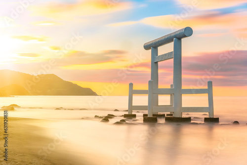 фотографія Sunset long exposure photography of a Japanese white wooden torii arch with its pillars in the sea along the Itoshima Beach of Fukuoka famous for Couple Rocks called Sakurai Futamigaura's Meoto Iwa