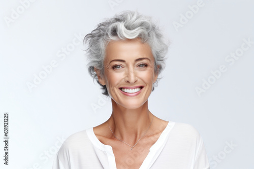 Happy 50s-aged woman, smiling, looking at camera. Isolated on white background. Beauty care products advertising concept.