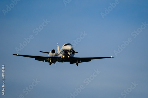  A small business jet approaches the airport with landing lights on.