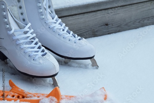 White, female skates stand in the snow 
