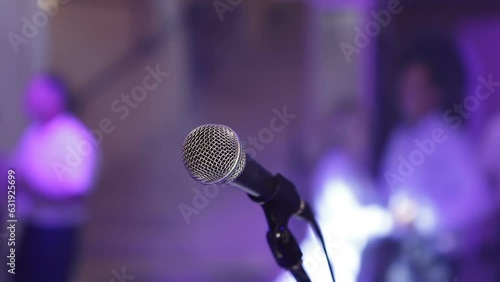 A musician plays the trumpet on stage near an acoustic microphone. People are dancing on the dance floor. Night club. Disco for older people.