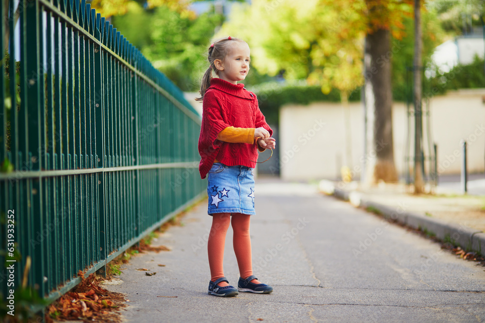 Adorable preschooler girl enjoying nice and sunny autumn day outdoors Adorable preschooler girl enjoying nice and sunny autumn day outdoors