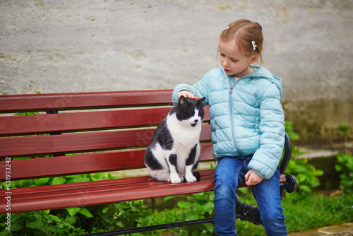 preschooler girl caressing a cat in Uskudar district on Asian side of Istanbul, Turkey