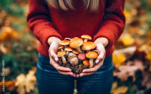 Girl in the forest holding a bunch of fresh wild mushrooms in autumn day 