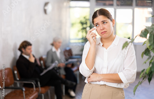 Photos Frustrated disappointed young businesswoman standing in office helplessly spreading her arms