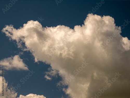 White clouds over blue sunset sky background. Fluffy cumulus cloudscape shape