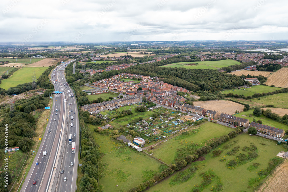 Aerial photo of the village of East Ardsley in the City of Leeds metropolitan borough, in West Yorkshire, England showing a typical British housing estate along side a busy motorway highway