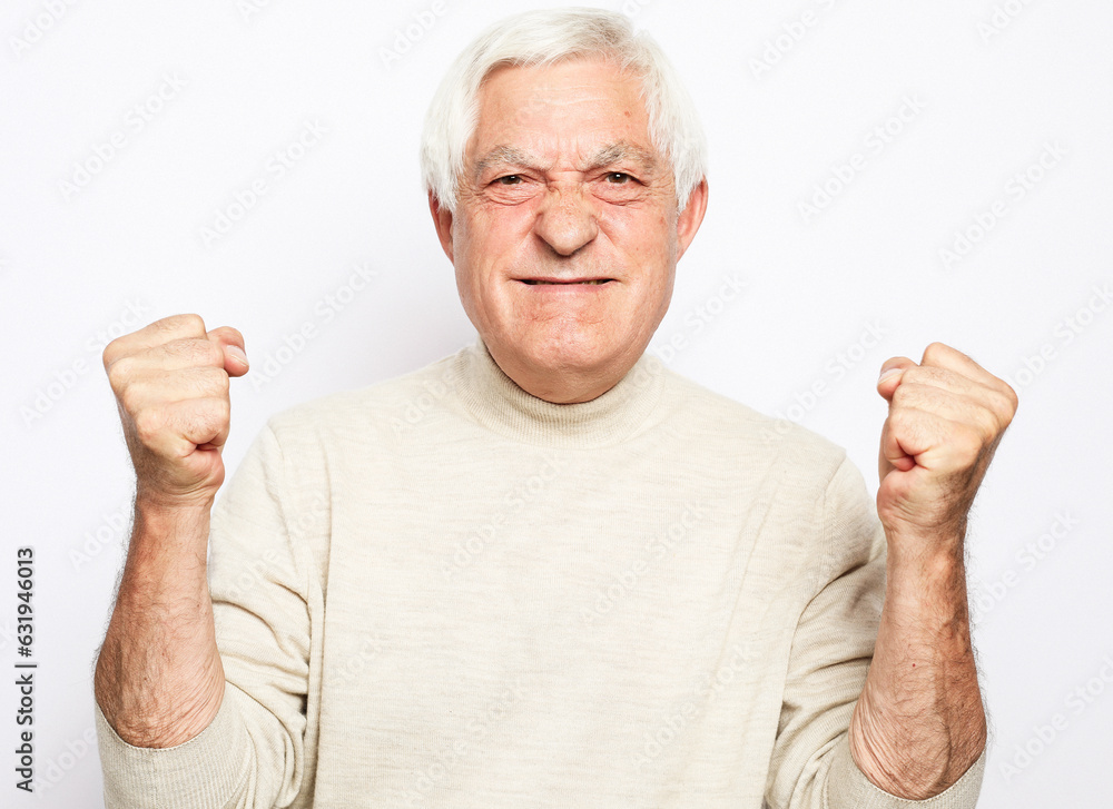 Senior man over isolated background doing happy thumbs up gesture with hands. Senior man over isolated background doing happy thumbs up gesture with hands.
