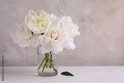 Beautiful peonies in glass vase on white table. Space for text © New Africa