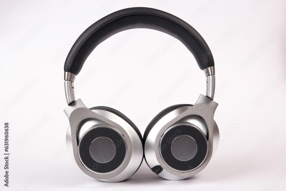 Stylish modern black and silver headphones on light background. Stylish modern black and silver headphones on light background.