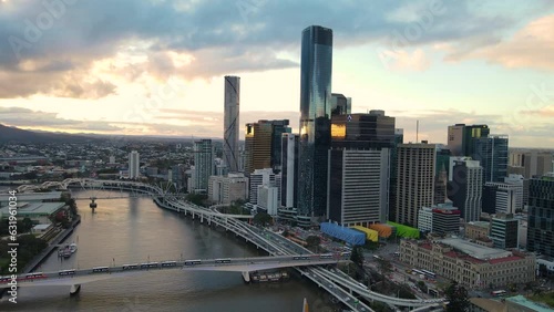 Aerial drone pullback reverses view of Brisbane City, QLD, Australia looking toward the west facing side of the city along Brisbane River and Riverside Expressway during late afternoon in August 2023  photo