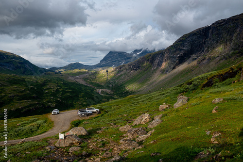 Wallpaper Mural Sunlit green mountain slopes on the way up to Rabothytta, Okstindan, Hemnes, Helgeland, Northern Norway. Green mountains of Nordnorge. Sunny patches on dark mountains. Cloudy dramatic skies and light. Torontodigital.ca