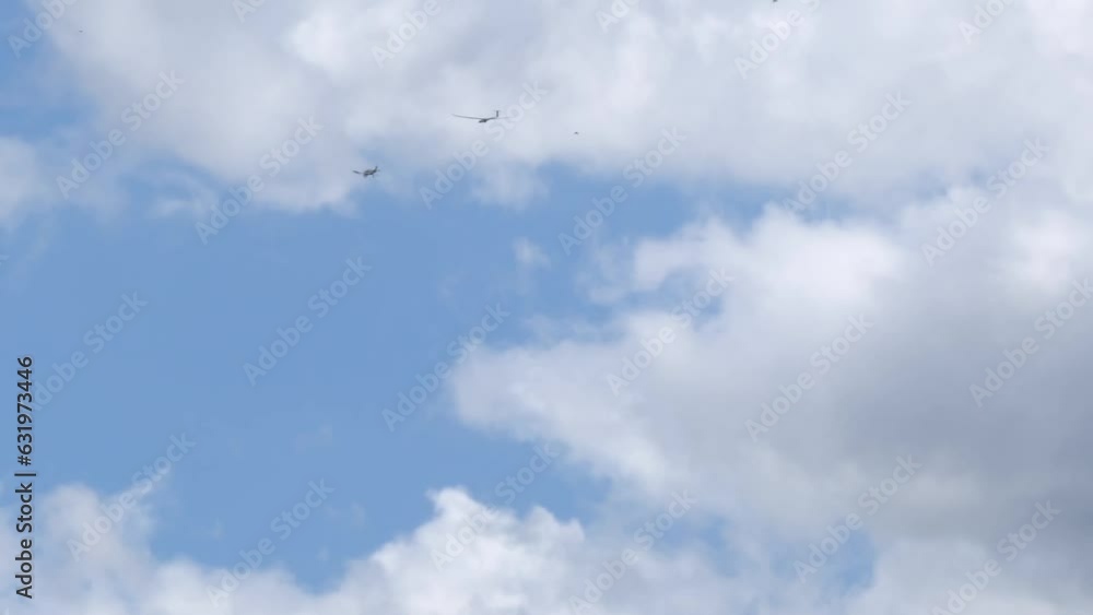 Motor plane pulling glider in blue cloudy sky, view from bellow Motor plane pulling glider in blue cloudy sky, view from bellow