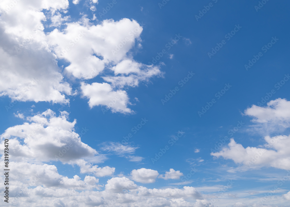 Obraz premium Panoramic view of clear blue sky and clouds, Blue sky background with tiny clouds. White fluffy clouds in the blue sky. Captivating stock photo featuring the mesmerizing beauty of the sky and clouds.