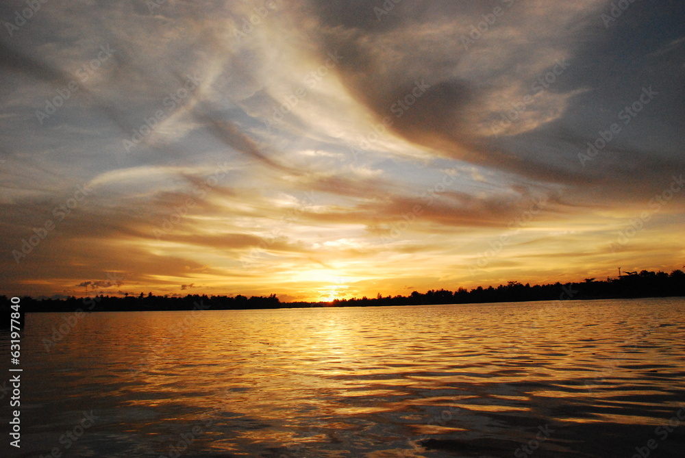 Fototapeta premium Scenic view dramatic beautiful sunset sky. Natural Sunset Sunrise on meadow silhouette shadow dark land. Vibrant dramatic sky on sunset, dawn, sunrise in Countryside. Landscape Colorful Sky At Sunset