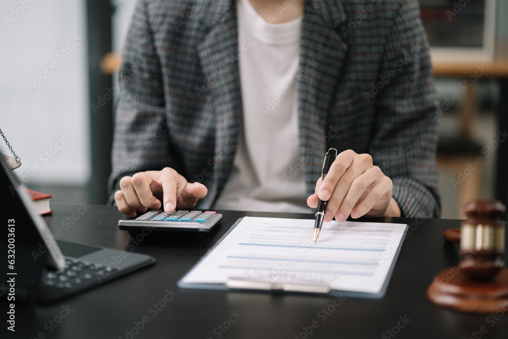 Lawyer or accounting department writes a note and uses a calculator to calculate expenses - income. at office lawyer. Lawyer or accounting department writes a note and uses a calculator to calculate expenses - income. at office lawyer.