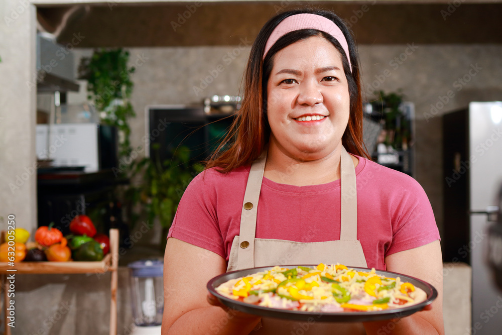Happy smiling asian fat female chef holding pizza to prepare and bake in the oven. Fast food concept. Happy smiling asian fat female chef holding pizza to prepare and bake in the oven. Fast food concept.