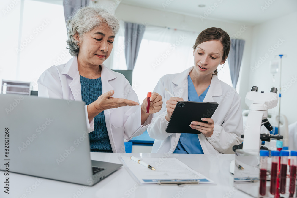Scientists are doing research in a medical laboratory. Foreground researcher using a microscope Scientists are doing research in a medical laboratory. Foreground researcher using a microscope