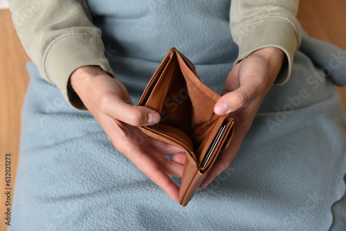 Eine Frau zeigt ihre leere Geldbörse