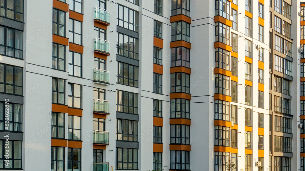 Fototapeta premium Facade of a multi-apartment residential building with windows and balconies