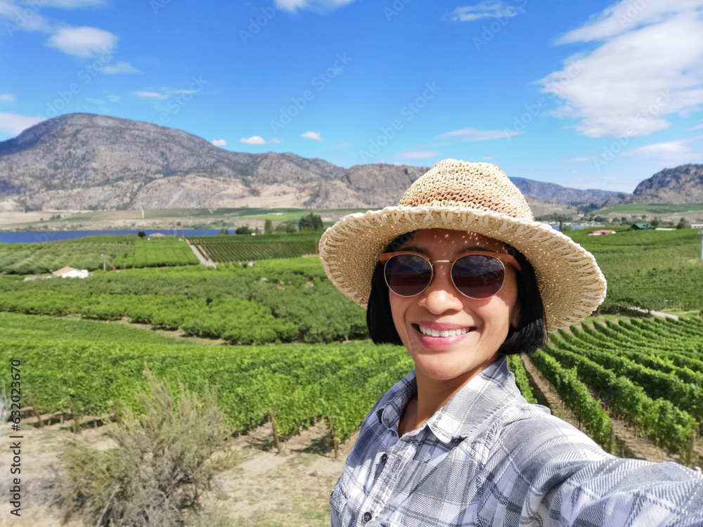 Selfie woman travel in vinyards, Okanagan valley, British Columbia Canada.