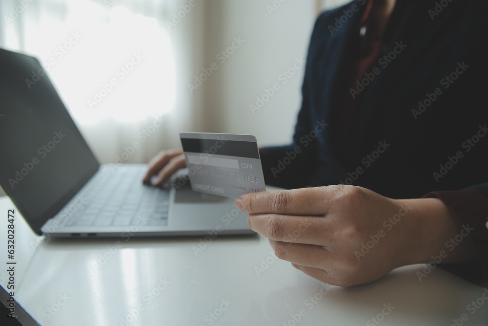 Woman hands holding and using cradit card for shopping online.