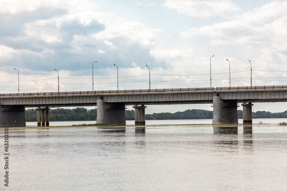 Concrete bridge across the river against the backdrop of clouds with the sky Concrete bridge across the river against the backdrop of clouds with the sky