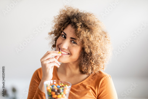 Smiling mid adult woman eating a cookie