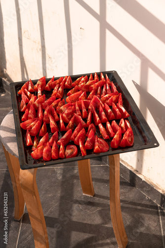 Sun-dried tomatoes on a pan. Fresh tomatoes © Nino Lavrenkova