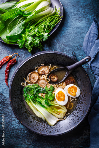 Fotografie Miso ramen Asian noodles soup with shiitake, egg and pak choi cabbage on dark ba