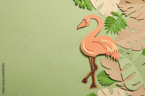Paper green tropical leaves on a green background. With a flamingo bird.