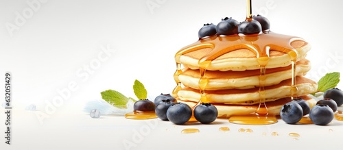 American pancakes topped with blueberries and maple syrup on a light background. Perfect for a sweet and delicious breakfast or dessert. Copy space available.