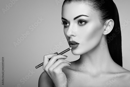Tableau sur toile Black and white photo of woman painting lipstick