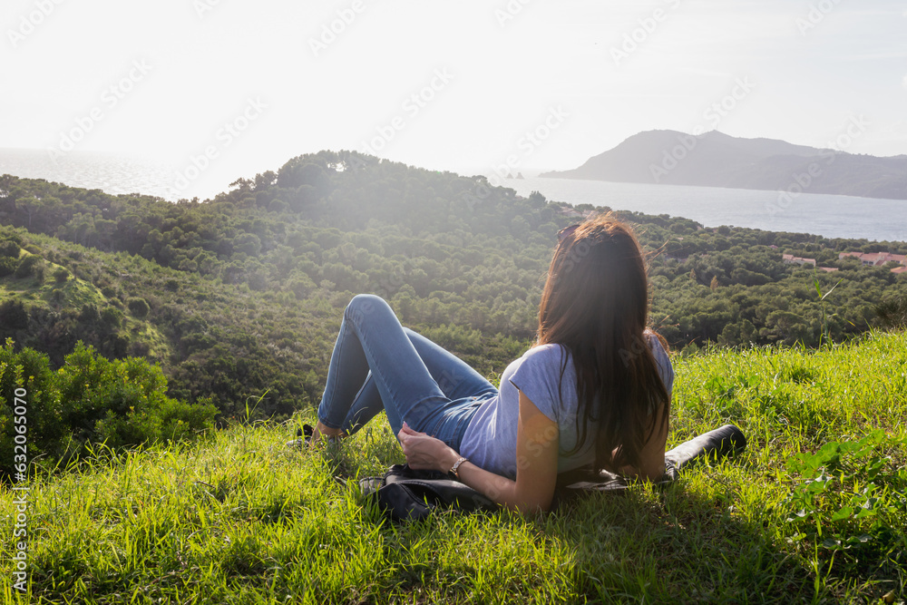 Naklejka premium woman in the mountains lying on the grass