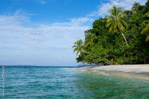 Scenic view of a remote tropical with coconut palm trees, white sandy beach and turquoise ocean water in Solomon Islands