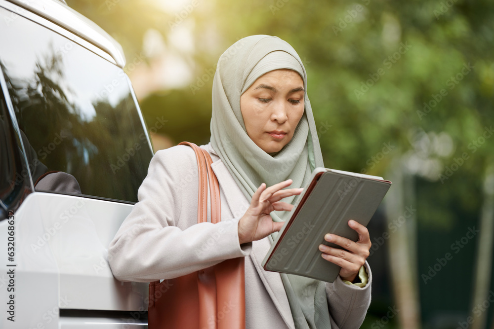 Serious mature muslim businesswoman reading document on digital tablet